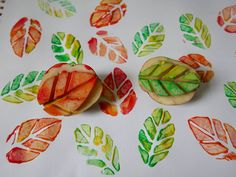 two pieces of fruit sitting on top of a white table cloth with leaves painted on it