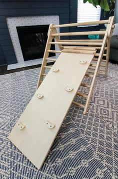 a large wooden slide sitting on top of a rug in front of a fire place