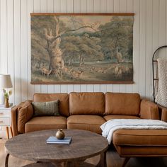 a living room filled with furniture and a painting hanging on the wall above it's headboard