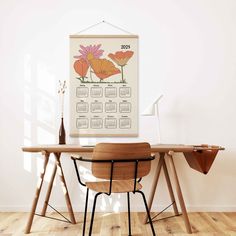 a desk with two chairs and a calendar hanging on the wall