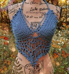 a crocheted top is displayed on a mannequin with butterflies around it