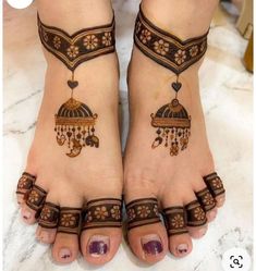 two feet with henna tattoos on them and one has a birdcage hanging from it