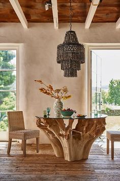 a dining room table and chairs with chandelier hanging from the ceiling