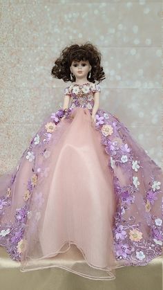 a doll is wearing a pink dress with flowers on it