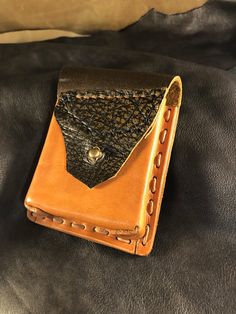 a leather wallet sitting on top of a bed