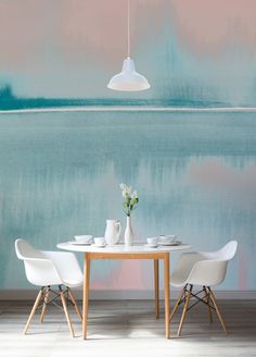 a dining room table with two chairs and a vase on the table in front of it