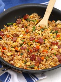 a skillet filled with rice and vegetables on top of a blue and white towel