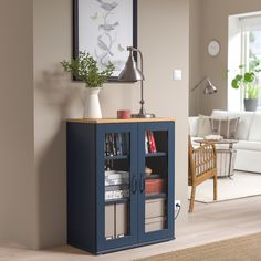 a living room with a blue cabinet and a lamp