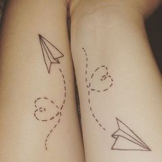 two people with matching tattoos on their arms, one has an airplane and the other has a rocket