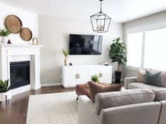 a living room filled with furniture and a flat screen tv mounted on the wall above a fireplace