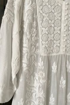 This White Muslin Silk Handcrafted Lucknowi Chikankari A Line Kurta Long Dress is a stunning piece of art. The beautiful white  dress  is perfect for any special occasion. The luxurious fabric and intricate Lucknowi Chikankari embroidery make it a timeless piece that will never go out of style.    Muslin silk    Length 48" inches   Long sleeves 18" inches  Round neck  A line   Lucknowi chikankari hand embroidered    Dry Clean    Fit:     True to size    Inside Margin:     No    Disclaimer:   Sin White Lakhnavi Kurta Design, White Lucknowi Kurta, Lakhnavi Suits, Office Kurti, White Chikankari Kurta, Lucknowi Chikankari Suits, Lucknowi Embroidery, Cotton Kurties, Chikan Kurta