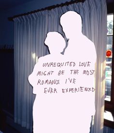 the silhouette of a man and woman are in front of a window with words written on it