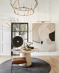 a modern dining room with white walls and wood flooring, an art piece on the wall