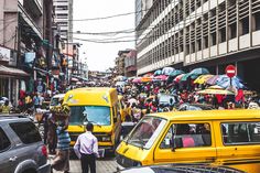 a busy city street filled with lots of traffic and people walking on the side walk