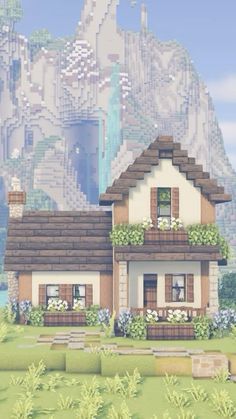 a small house in front of a mountain with flowers on the windows and bushes around it