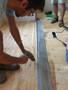 a man is working on some wood flooring