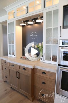 a kitchen with wooden cabinets and white walls, along with a chalkboard on the wall that says welcome