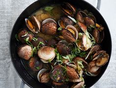 clams and greens in a skillet on a table