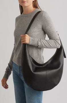 This slouchy bag is cool, modern and quietly luxe, and features a secure top zipper and interior pocket. The interior is roomy enough to hold your tablet, water bottle, phone, wallet and keys. Plus, it has an adjustable strap that can be worn crossbody or over the shoulder. Top zip closure Adjustable shoulder strap Interior wall pocket Lined Leather Imported Black Leather Purse Outfit, Modern Shoulder Bag With Zipper Closure, Modern Shoulder Bag With Zipper Pocket, Modern Hobo Bag For Everyday Use, Modern Crossbody Hobo Bag With Zipper Pocket, Modern Hobo Bag For Travel, Chic Office Hobo Bag With Zipper Pocket, Modern Hobo Bag With Zipper Closure For Office, Modern Hobo Bag For On-the-go