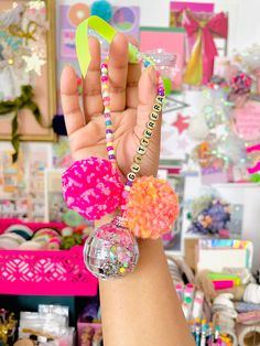 a person holding up a bracelet with beads and pom - poms on it