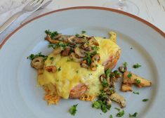 a white plate topped with an omelet covered in mushrooms