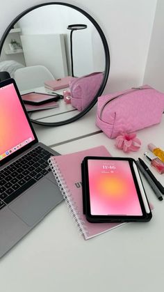 an open laptop computer sitting on top of a desk next to a mirror and other items