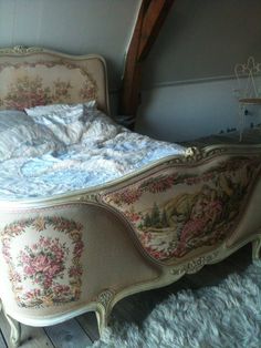 an old fashioned bed with floral designs on it