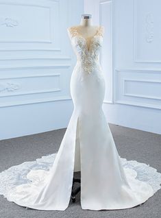 a white wedding dress on display in a room