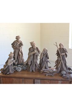 a group of figurines sitting on top of a wooden table next to each other