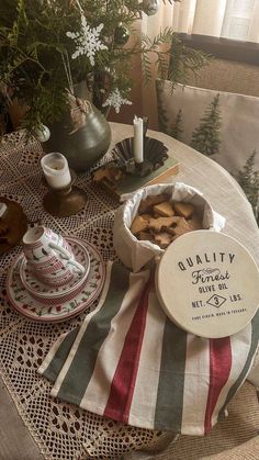 a table topped with plates and bowls filled with food next to a potted plant