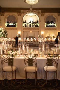 the tables are set up with white linens and candles for an elegant wedding reception