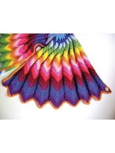 a multicolored knitted scarf on top of a white table