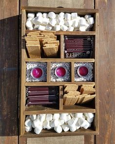 a wooden box filled with marshmallows and other treats