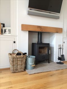 a living room with a wood burning stove and basket on the floor next to it