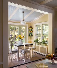 an open kitchen and dining room area with sun shining through the windows on the wall