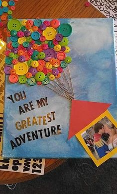 there is a book with buttons on it and a photo in the middle that says you are my greatest adventure