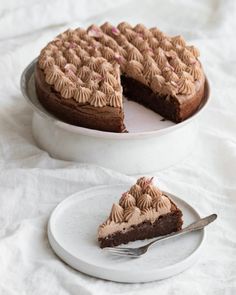 a piece of chocolate cake on a white plate with a slice taken out of it