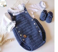 a blue knitted baby outfit and booties on a white surface