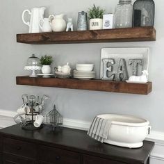 two wooden shelves with dishes and cups on them