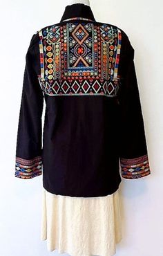 Wearable Art In This Elaborate Hand Embroidered Short Jacket in black. Exquisite craftsmanship handcrafted with intricate embroidery incorporating all the colors in the spectrum. Each stitch tells a story of tradition and elegance. 100% Cotton, hand embroidered. Mock collar, engineered front placket border, matching finish on hem and cuffs . This eye-catching piece is perfect for any occasion. It's unique design features intricate details and embroidered patterns that are sure to make a statement. Embroidery is presented in sections. Cuffs have multiple rows of unique stitching. Breast panels also illustrate a totally different stitch. 2 pockets on each side for everyday essentials. True designer quality, back shoulder panel is dramatic and makes a designer statement. Easy fit jacket is co Suzani Embroidery, Embroidered Patterns, Different Stitches, Black Peach, Intricate Embroidery, Stitch 2, Embroidered Shorts, Vintage Textiles, Workout Jacket