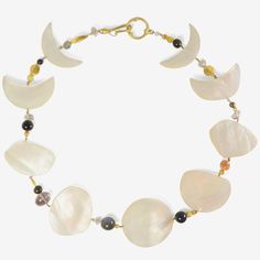 Details Gabriella Kiss 18k yellow gold & mother-of-pearl phases of the moon necklace with blue goldstone, herkimer diamonds, Ethiopian opal, labradorite, amethyst, pyrite, moonstone & 22k beads. The mother-of-pearl full moon measures approximately 1 3/8″ in diameter. The total length of the necklace is 17 1/2″ & it is finished with an 18k clasp. - custom-cut mother-of-pearl - 18k yellow gold - total length 17 1/2" Luxury Moon Shaped Necklace, Unique Gemstone Necklace With Mother Of Pearl, Elegant Crescent Moonstone Necklace, Celestial Moon-shaped Natural Stone Necklace, Luxury Handmade Mother Of Pearl Necklace, Elegant Moonstone Necklace With Moon Phase Detail, Elegant Moonstone Necklace With Moon Phase, Elegant Moon-shaped Jewelry With Natural Stones, Elegant Moon Shaped Jewelry With Natural Stones