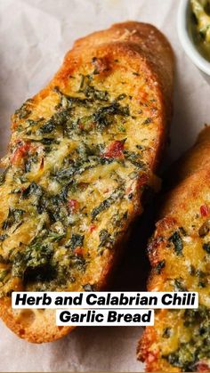 two pieces of bread with spinach and cheese on them next to a bowl of dip