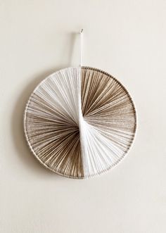 a white and brown wall hanging on the side of a wall