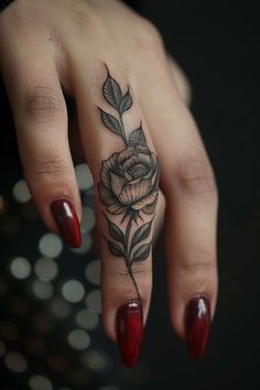 a woman's hand with a rose tattoo on it