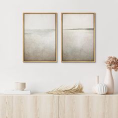 two framed paintings on the wall above a dresser with vases and other items in front of it