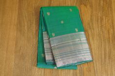 This stunning trendy kanchipuram saree is ready to wear for all occasions comes with a lovely peacock green color and peacock and coin butta all over the body. It comes with a silver zari border and a self attached blouse. Blouse is unstitched.  Wash Care: Dry Wash Note: Product color may slightly vary due to photographic lighting sources or your screen settings. Elegant Green Saree For Puja, Green Handloom Traditional Wear For Celebration, Elegant Green Traditional Handloom Wear, Elegant Green Traditional Wear Handloom, Green Tussar Silk Saree For Celebration, Elegant Green Paithani Silk Traditional Wear, Elegant Green Paithani Silk Dupatta, Festive Green Traditional Wear With Peacock Design, Green Saree With Peacock Design In Traditional Drape