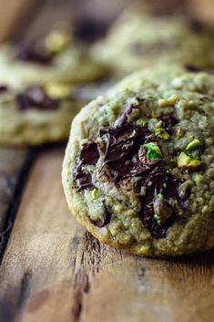 cookies with chocolate chips and pistachios on a wooden table, ready to be eaten