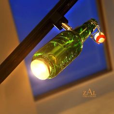 a green glass bottle hanging from a light fixture