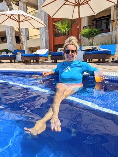 a woman sitting on the edge of a swimming pool