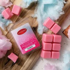 soap cubes on a cutting board next to cotton floss and other items that are pink